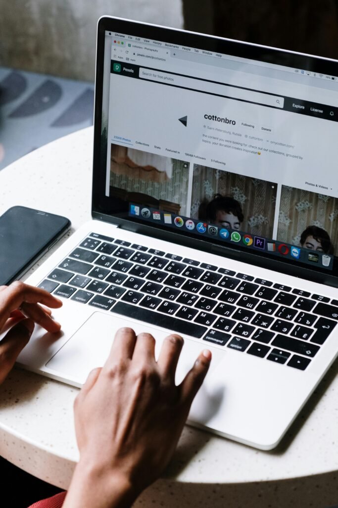 Person typing on laptop at a café table, ideal for tech and freelance themes.